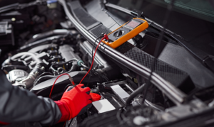 mechanic checking voltage of car battery. Car battery replacement in gatton